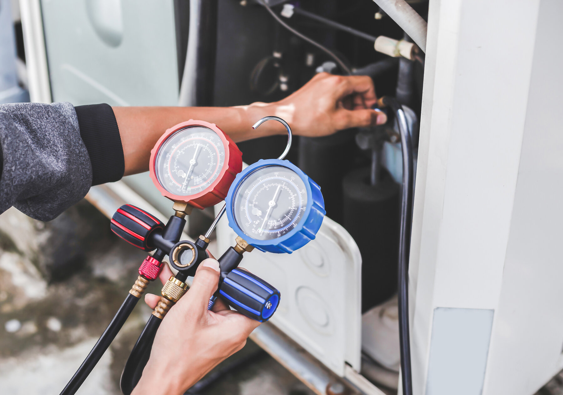 Kältemittel-Diagnose mit Manometer Kältetechniker prüft Druck einer Klimaanlage mit Manometer-Set